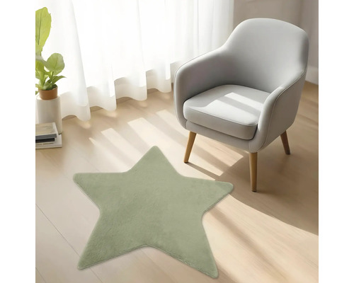 Grüner sternenförmiger Plüschteppich auf Holzboden in einem hellen Zimmer mit Sessel und Pflanze.