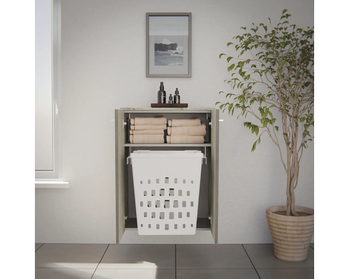 Armoire de salle de bain encastrée avec panier à linge coulissant intégré et étagère pour serviettes pliées.