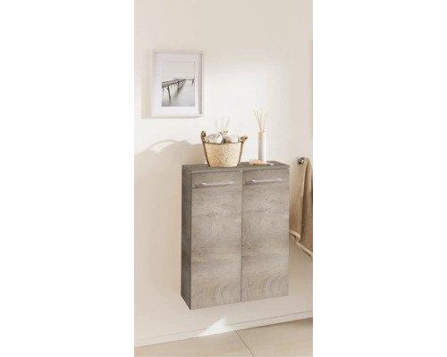 Meuble de salle de bain suspendu aspect bois gris à deux portes, décoré d'un panier à serviettes et d'un diffuseur.