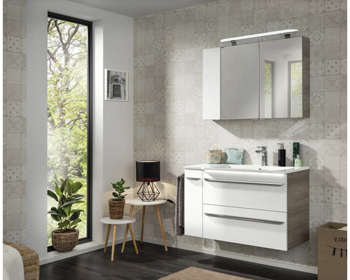 Modernes Badezimmer mit Waschtischunterschrank in Weiss und Holzoptik, Waschbecken und dreitürigem Spiegelschrank mit LED-Beleuchtung.
