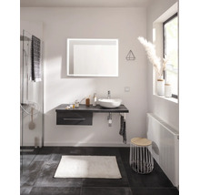 Salle de bains moderne avec meuble sous-vasque suspendu, vasque à poser blanche, miroir LED rectangulaire et douche en verre.