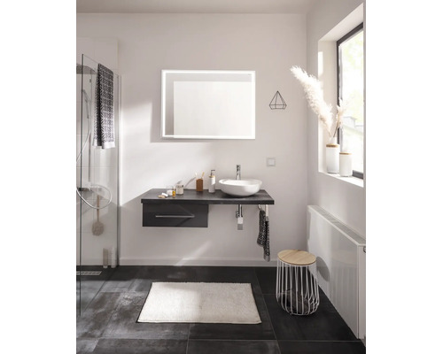 Salle de bains moderne avec meuble sous-vasque suspendu, vasque à poser blanche, miroir LED rectangulaire et douche en verre.