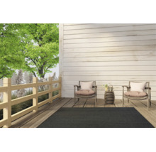 Tapis d'extérieur gris foncé sur une terrasse moderne en bois avec deux fauteuils et une petite table d'appoint.