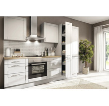 Cuisine intégrée lumineuse de style campagnard avec plan de travail imitation bois, four encastré, hotte et armoire à provisions coulissante.