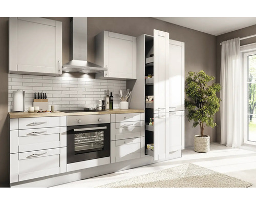 Cuisine intégrée lumineuse de style campagnard avec plan de travail imitation bois, four encastré, hotte et armoire à provisions coulissante.