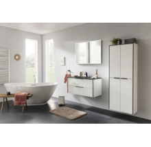 Ensemble de salle de bains moderne composé d'un meuble sous-vasque blanc avec détails noirs, d'une armoire haute et d'un grand miroir.