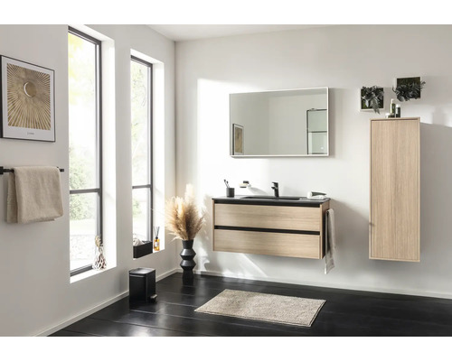 Salle de bain moderne avec meuble sous-lavabo clair aspect bois, vasque noire, armoire haute assortie et grand miroir rectangulaire.