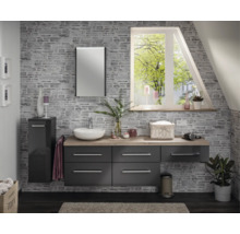 Salle de bain moderne avec meubles gris foncé, plan de toilette aspect bois, vasque à poser, miroir et mur aspect pierre.