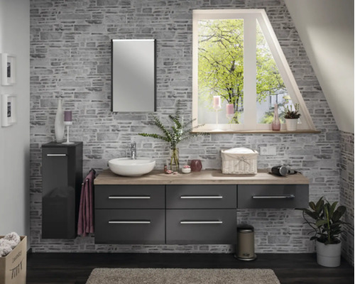 Salle de bain moderne avec meubles gris foncé, plan de toilette aspect bois, vasque à poser, miroir et mur aspect pierre.