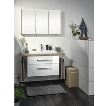 Ensemble de salle de bain moderne comprenant meuble sous-vasque blanc à deux tiroirs, plateau en bois, vasque en céramique et armoire à trois portes.