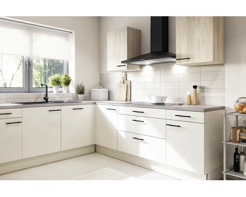 Cuisine d'angle moderne et lumineuse avec façades blanches, poignées noires, meubles hauts aspect bois, hotte aspirante noire et plan de travail gris.