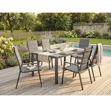 Ensemble de jardin avec table rectangulaire et six chaises à accoudoirs sur une terrasse en bois au bord d'une piscine dans un jardin aménagé.
