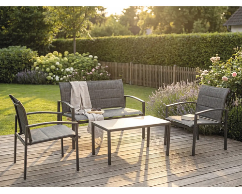 Salon de jardin moderne en métal et textile sur une terrasse en bois, comprenant une banquette, deux fauteuils et une table basse.