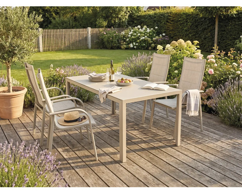 Gartenmöbel-Set mit einem rechteckigen Esstisch und vier Hochlehner-Stühlen auf einer Holzterrasse in einem hellen, gepflegten Garten.