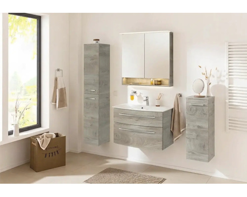 Ensemble de salle de bain moderne aspect chêne gris avec meuble sous-vasque, armoire de toilette et armoires latérales dans une pièce lumineuse.