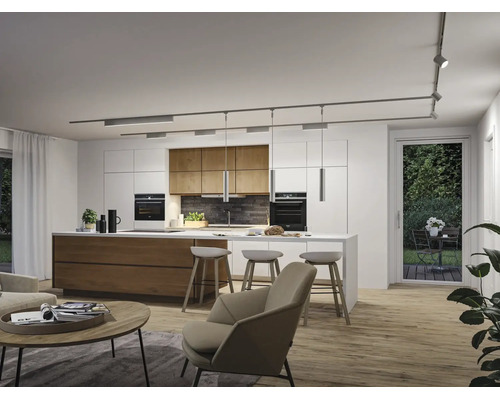Moderne offene Küche mit Insel, Barhockern und Schienensystem an der Decke. Wohnbereich mit Sessel und Couchtisch im Vordergrund.