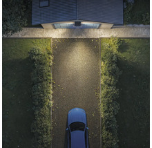 Vogelperspektive einer Garageneinfahrt bei Nacht, beleuchtet durch eine Solar Außenleuchte mit Bewegungsmelder über dem Garagentor.