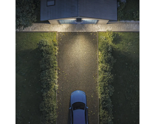 Vogelperspektive einer Garageneinfahrt bei Nacht, beleuchtet durch eine Solar Außenleuchte mit Bewegungsmelder über dem Garagentor.