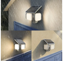 Solar-LED-Außenstrahler mit drei Leuchtköpfen und Bewegungsmelder, montiert an einer Wand bei Regen, Schnee und Sonnenschein.