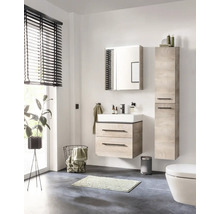 Salle de bains lumineuse avec ensemble de meubles aspect bois comprenant meuble sous-vasque, vasque, armoire de toilette et colonne.