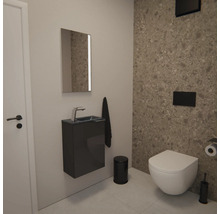 Modernes Gäste-WC mit Wand-WC, dunklem Waschtischunterschrank, Spiegel und Wandfliesen in Natursteinoptik im minimalistischen Stil.