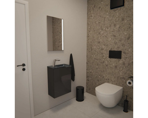 Modernes Gäste-WC mit Wand-WC, dunklem Waschtischunterschrank, Spiegel und Wandfliesen in Natursteinoptik im minimalistischen Stil.