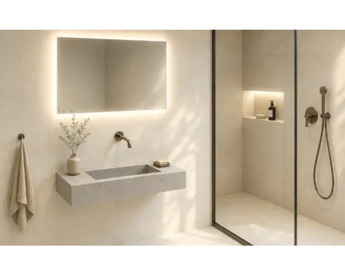 Salle de bains moderne avec un lavabo mural, un miroir éclairé et une douche en verre avec niche murale.