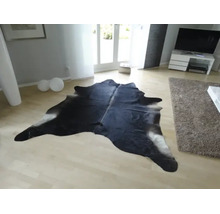 Kuhfell-Teppich in einem hellen, modernen Wohnzimmer auf hellem Holzboden.