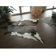 Tapis en peau de vache en cuir véritable dans un salon moderne avec parquet.