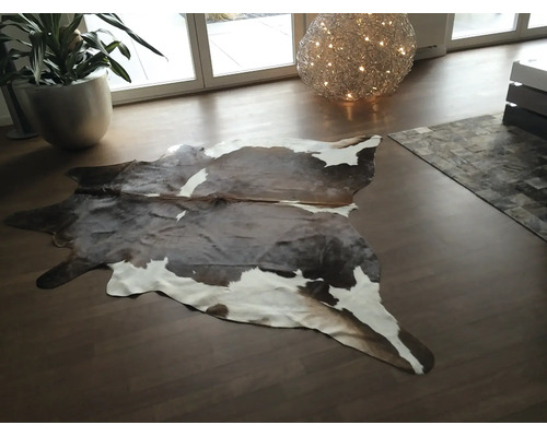 Tapis en peau de vache en cuir véritable dans un salon moderne avec parquet.