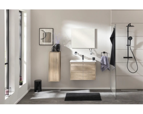 Ensemble de salle de bain moderne aspect chêne avec meuble sous-vasque, miroir, colonne et système de douche noir dans une pièce lumineuse.