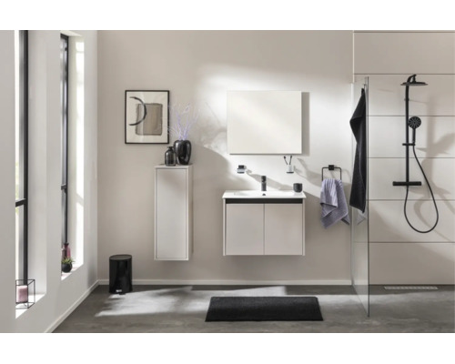 Modernes, helles Badezimmer mit weissem Waschtischunterschrank, Hochschrank, Spiegel und schwarzem Duschsystem mit Regenduschkopf.