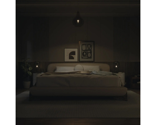 Chambre à coucher moderne avec lit rembourré, tableaux abstraits et éclairage par suspension et lampes de chevet.