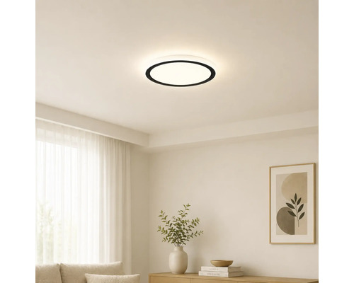 Plafonnier LED rond moderne avec bord noir dans un salon lumineux et minimaliste avec des murs blancs et des meubles clairs.