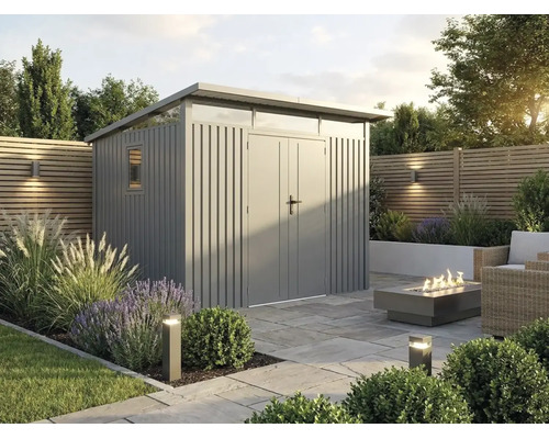 Modernes Metall-Gartenhaus mit Pultdach und Doppeltür in einer Gartenanlage mit Steinplatten-Terrasse, Feuerstelle und Zierpflanzen.