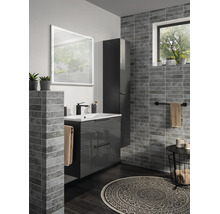 Salle de bain moderne avec meuble sous-vasque gris foncé, miroir LED, armoire haute et carrelage mural aspect pierre grise.