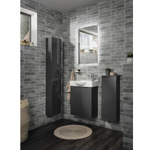 Salle de bain moderne avec meubles gris foncé comprenant une armoire haute, un sous-lavabo et un meuble latéral sur des murs carrelés gris.