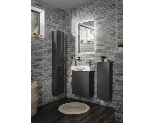 Salle de bain moderne avec meubles gris foncé comprenant une armoire haute, un sous-lavabo et un meuble latéral sur des murs carrelés gris.
