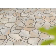 Polygonalplatten aus Naturstein für Terrasse oder Gartenweg, unregelmäßig geformt mit dunklen Fugen.