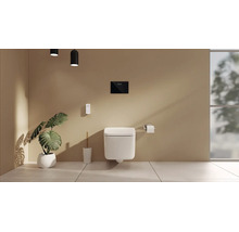 Salle de bains moderne avec WC suspendu, plaque de déclenchement, télécommande, brosse de toilette et plante Monstera.
