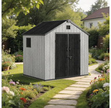 Abri de jardin avec double porte et toit en pente dans un jardin fleuri avec chemin en pierre