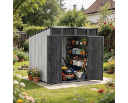 Abri de jardin avec toit en pente et doubles portes ouvertes, équipé d'étagères, d'outils de jardinage et d'une tondeuse dans un jardin fleuri.