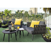Moderne Loungegruppe mit zwei Sesseln und zwei runden Tischen auf einer Dachterrasse mit Pflanzen und Stadtblick.