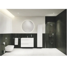 Modernes Badezimmer mit weißem Waschtischunterschrank, rundem Lichtspiegel, Hochschrank und begehbarer Dusche vor dunklen Wandfliesen.