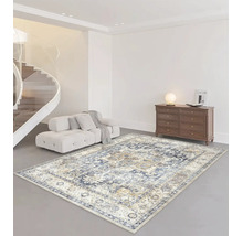 Großer rechteckiger Teppich mit vintage Orientmuster in einem hellen Wohnzimmer mit Sofa, Holzkommode und moderner Treppe.