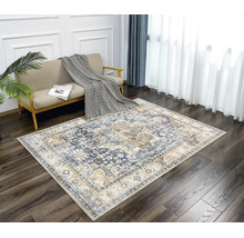 Rechteckiger Teppich mit orientalischem Vintage-Muster in einem hellen Wohnzimmer mit dunklem Holzboden und beigem Sofa.