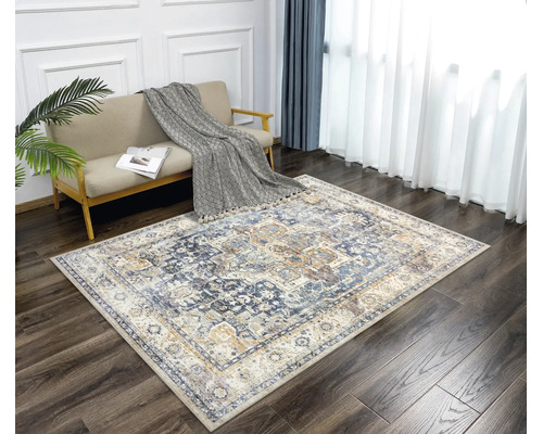 Rechteckiger Teppich mit orientalischem Vintage-Muster in einem hellen Wohnzimmer mit dunklem Holzboden und beigem Sofa.