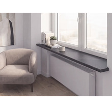 Scène de pièce moderne avec rebord de fenêtre sombre au-dessus d'un radiateur blanc, fauteuil rembourré clair et parquet.