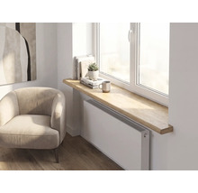 Intérieur moderne avec un rebord de fenêtre en bois épais aux bords arrondis au-dessus d'un radiateur dans une pièce lumineuse et organisée.