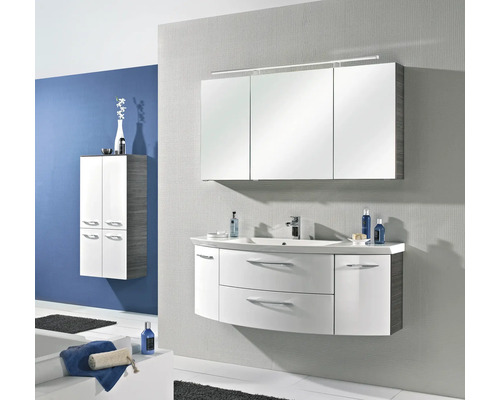 Ensemble de salle de bain moderne avec meuble sous-lavabo blanc galbé, armoire de toilette à trois portes avec éclairage et armoire haute assortie.